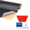 Schwarze Kunstlederrolle mit strukturierter Oberfläche, die die Klebeseite zeigt, neben roten und blauen Rakeln, einem Cuttermesser und Ersatzklingen Anteprima dell’immagine prodotto