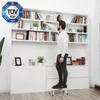 A man is standing on a step stool in front of a bookshelf, reaching for a book. Anteprima dell’immagine prodotto