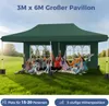 A group of people are sitting on the grass in front of a green pavilion. Voir les images du produit