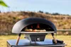 A pizza oven is shown outdoors on a table, with a pizza cooking inside. Produktbild-Vorschau