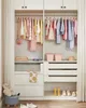 A well-organized children's closet with clothes hanging and folded, along with storage bins and shoes. Náhled obrázku produktu