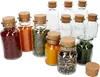A collection of glass spice jars with cork stoppers, some filled with various spices and herbs. Podgląd zdjęcia produktu