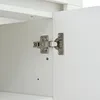 A close-up view of a cabinet hinge on a white cabinet. Anteprima dell’immagine prodotto