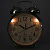 A close-up shot of a retro analog alarm clock with illuminated numbers. Voir les images du produit