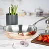A copper frying pan is displayed on a kitchen counter with some ingredients. Anteprima dell’immagine prodotto