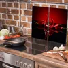 A kitchen scene with a stovetop, cooking utensils, and vegetables. Anteprima dell’immagine prodotto