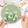Hands are shown working on a punch needle embroidery kit with a floral pattern. Produktbild-Vorschau