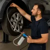 A mechanic is using a brake bleeding tool on a car's wheel. Produktbild-Vorschau