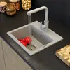 A kitchen sink with running water, tomatoes, and a faucet. Produktbild-Vorschau
