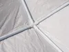 Close-up view of the white PVC pipe frame of a tent or gazebo, showing the corner connectors and the white fabric material. Náhled obrázku produktu