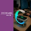 A desk with a lamp that has a wireless charger and a phone on it, with a person typing on a keyboard in the background. Náhled obrázku produktu