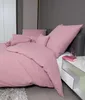 A neatly made bed with pink bedding and pillows. Produktbild-Vorschau