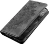 A black flip phone case with a mandala design embossed on the cover, shown from a diagonal angle. Produktbild-Vorschau