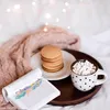 A cozy scene with a book, pancakes, and hot chocolate on a bed. Produktbild-Vorschau