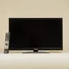 A Telefunken television with a remote control in front of a plain background. Produktbild-Vorschau