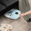 A person's hand is reaching for a blue foot spa placed under a black couch, with slippers on the floor. Anteprima dell’immagine prodotto