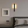 A modern bedroom setting with a bed, nightstand, and a wall lamp. Anteprima dell’immagine prodotto