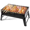 A portable charcoal grill with food cooking on it. Produktbild-Vorschau