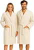 A man and a woman are standing side-by-side, both wearing cream-colored bathrobes. Produktbild-Vorschau