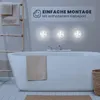 A bathroom scene with a bathtub, towels, and three LED lights mounted on the wall. Produktbild-Vorschau