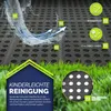 A close-up of a black textured mat with circular holes, partially covered by grass, with water splashing on it and arrows indicating water flow. There are also circular icons with text and numbers. Náhľad obrázku produktu