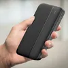 A hand holding a black power bank. Produktbild-Vorschau