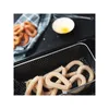 A close-up view of uncooked churros in a frying basket, with a blurred background showing a whisk and a bowl with an egg yolk. Náhľad obrázku produktu