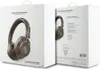 Two boxes of Guess wireless headphones are shown side-by-side against a white background. The front of the left box displays a pair of brown headphones with a gold Guess logo pattern. The right box shows the back of the packaging, detailing product specifi Anteprima dell’immagine prodotto