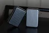 Two small, rectangular cases with ribbed exteriors are placed on a dark surface. Anteprima dell’immagine prodotto