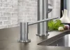 A close-up shot of a stainless steel soap dispenser and faucet on a kitchen countertop. Produktbild-Vorschau