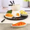 A ceramic fondue set with various ingredients like broccoli, carrots, potatoes, and bell peppers arranged around it. Náhled obrázku produktu