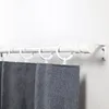 A white curtain rod with rings and gray curtains attached, mounted on a white wall. Voir les images du produit