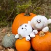 Two plush toys, Pluto and Charon, are sitting on pumpkins. Produktbild-Vorschau