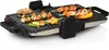 A close-up shot of a multi-functional grill with various foods being cooked on it. Podgląd zdjęcia produktu