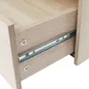 Close-up view of an open drawer with its metal slides, showcasing the wood grain texture of the furniture. Podgląd zdjęcia produktu