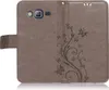 A brown flip case for a smartphone, decorated with a floral and butterfly pattern. Produktbild-Vorschau