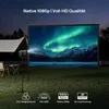 A projector is set up outdoors at night, projecting an image of the aurora borealis onto a screen. A tent and camping chairs are visible in the background. Produktbild-Vorschau