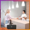 A woman is checking in at a reception desk with a suitcase next to her. Anteprima dell’immagine prodotto