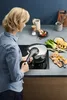 A woman is cooking in a kitchen with a pressure cooker. Náhled obrázku produktu