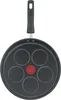The underside of a black pancake pan with five circular indentations and a red central indicator. Voir les images du produit