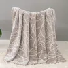 A beige blanket with a white geometric pattern is draped over a surface. Podgląd zdjęcia produktu