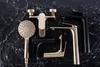 A collection of modern bathroom faucets and a shower head arranged on a dark, textured surface. Náhľad obrázku produktu