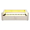 A beige upholstered daybed with a slatted mattress base and integrated LED lighting in the headboard. Produktbild-Vorschau