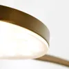 A close-up shot of a modern lamp with a bronze-colored rim and a bright white light source. Anteprima dell’immagine prodotto