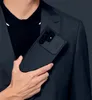 A person in a suit holding a smartphone with a protective case. Anteprima dell’immagine prodotto