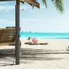 A beach scene with a solar shower, wooden seating, and beach umbrella. Náhľad obrázku produktu