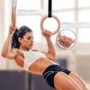 A woman is performing a workout using gymnastic rings. Produktbild-Vorschau