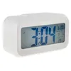 A white digital alarm clock with a blue LCD screen displaying the time, date, alarm, and temperature. Náhled obrázku produktu