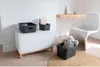 A modern room with a white dresser, a wooden desk, and a white chair, featuring storage baskets. Anteprima dell’immagine prodotto