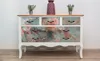 A dresser with a marble pattern on the drawers, decorated with two small potted plants and a vase on top. Náhľad obrázku produktu